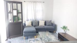a living room with a blue couch and a window at B3 bnb House in Ravensmead