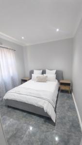a bedroom with a large bed with white sheets and pillows at B3 bnb House in Ravensmead
