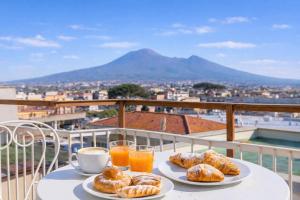 a table with two plates of pastries and orange juice at Aurum Pompei Suites in Pompei