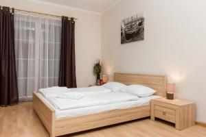 um quarto com uma cama grande e lençóis brancos em Apartamenty Regina Maris em Świnoujście
