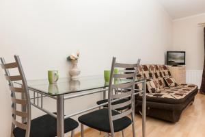 a dining room with a glass table and chairs at Apartamenty Regina Maris in Świnoujście