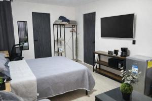 a bedroom with a bed and a flat screen tv at Depto Tec by tuhost in Monterrey