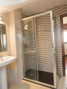 a glass shower in a bathroom with a sink at Atico con terraza al mar in Mogro