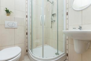 uma casa de banho com um chuveiro, um WC e um lavatório. em Apartamenty Regina Maris em Świnoujście