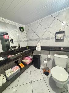a bathroom with a toilet and a sink at Pousada Tia Moni in Blumenau