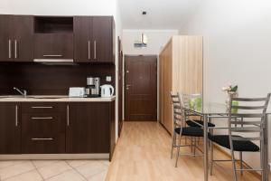 uma cozinha com armários de madeira e uma mesa e cadeiras em Apartamenty Regina Maris em Świnoujście