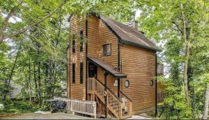 a small wooden house with a staircase in the woods at Fall Season Mtn Views, Hot Tub, Sauna, close to Downtown! in Gatlinburg
