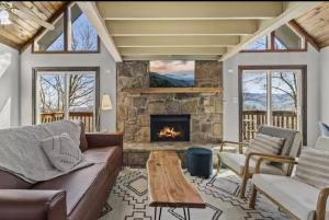 a living room with a couch and a fireplace at Fall Season Mtn Views, Hot Tub, Sauna, close to Downtown! in Gatlinburg