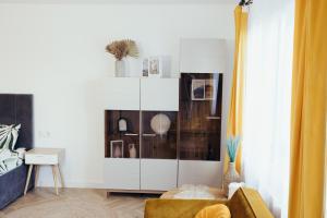 a living room with a large white cabinet at IUGAs RESIDENCE in Sighetu Marmaţiei