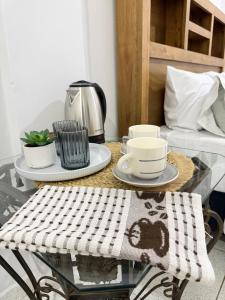 a glass table with a coffee maker and cups on it at Habitación centro in Ciudad del Este +4 photos