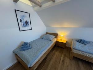 a bedroom with two beds and a lamp on a floor at Melem Apartments 2 in Langen