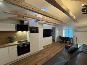 a living room with a couch and a kitchen at Melem Apartments 2 in Langen