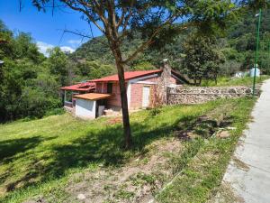a small house on the side of a hill at Oasis Hotel & Resort Mazamitla in Caliguana