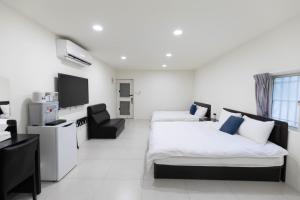 a hotel room with two beds and a chair at Home Rest B&B in Lijia