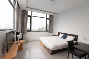 a hotel room with a bed and a desk with a computer at Home Rest B&B in Lijia