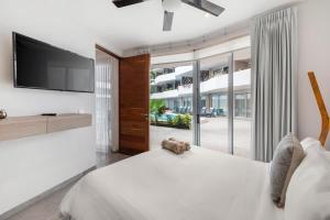 a bedroom with a large bed with a flat screen tv at 2bed apartment 500m from beach in Playa del Carmen