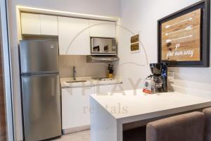 a kitchen with a stainless steel refrigerator and a counter at Luxury Condo in central location in Playa del Carmen