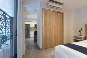 a bedroom with a bed and a sliding door at Luxury Condo in central location in Playa del Carmen