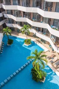 an aerial view of a hotel pool with palm trees at Luxury Condo in central location in Playa del Carmen +10 photos