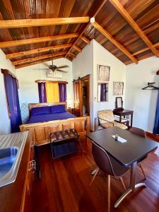 a bedroom with a bed and a table at Sunshine Cabanas At Ocean View in Dangriga
