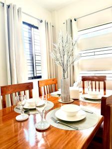 a dining room with a wooden table and chairs at The Eastcape by Akeisha in Bacolod