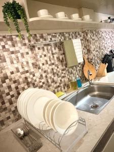 a kitchen with a sink and a plate on a counter at The Eastcape by Akeisha in Bacolod +27 photos