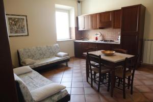 a living room with a table and a kitchen at Agriturismo Casa degli Archi in Lapedona