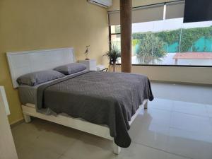 ein Schlafzimmer mit einem Bett und einem großen Fenster in der Unterkunft FIESTA MIRAMAR in Ciudad Madero + 149 Fotos