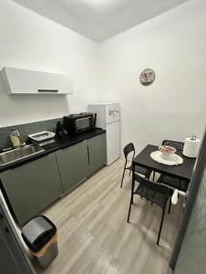a small kitchen with a table and a kitchen with a sink at Kjara's Nest in Neoi Epivates