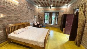 a bedroom with a bed and a brick wall at AV Meadows in Kanchipuram
