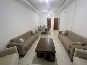 a living room with couches and a table and chairs at Paradise Palms Vacation Rentals in Mīdān az Zīr