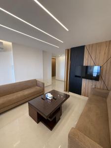 a living room with a couch and a coffee table at Paradise Palms Vacation Rentals in Mīdān az Zīr