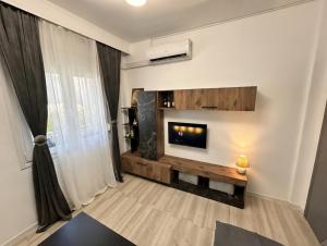 a living room with a fireplace and a tv at Kjara's Nest in Neoi Epivates