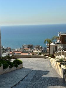 a walkway with a view of a city and the ocean at Paradise Palms Vacation Rentals in Mīdān az Zīr