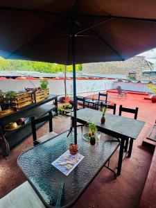 a table and chairs with an umbrella on a patio at Hostal Ixchel - AC, WiFi & Tours in Valladolid Downtown in Valladolid