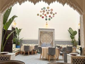 a dining room with tables and chairs and a wall with a moroccan pattern at Riad Azul Fes & SPA in Fez