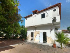 a white house with a mural on the side at Aconchego da Nina in Jijoca de Jericoacoara
