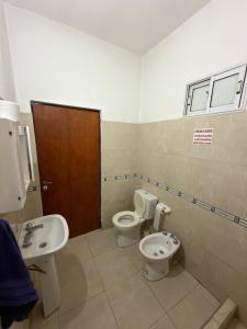 a bathroom with a toilet and a sink at Apart Sur Catriel in Catriel +4 photos