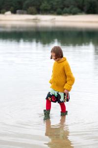a young girl is standing in a body of water at Leśny Chill House in Grodziec