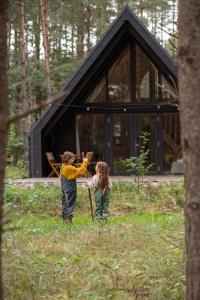 a man and a woman standing in front of a cabin at Leśny Chill House in Grodziec +33 photos