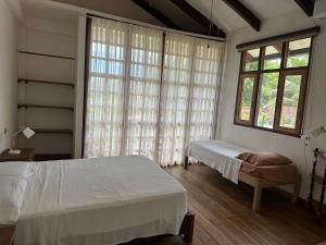 a bedroom with two beds and a large window at Casa de Campo in Rurrenabaque