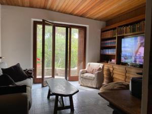 a living room with a couch and a tv at Villa Rocchetta in Casa Mora
