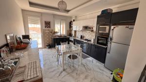 a kitchen with a refrigerator and a table in it at Apartment in secure residence in Constantine