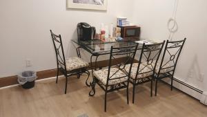 a glass table with two chairs and a phone on it at King-bed room with private bath -FREE WIFI-- New London-Mystic in New London