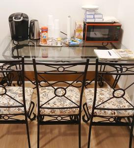 a glass table with two chairs and a microwave at King-bed room with private bath -FREE WIFI-- New London-Mystic in New London