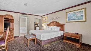 a hotel room with a bed and a desk at Red Arrow Inn & Suites, a Travelodge by Wyndham in Montrose