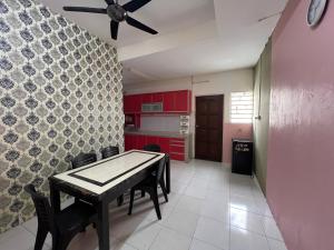 a kitchen with a table and a ceiling fan at Homestay Adelia SI in Seri Iskandar +10 photos