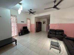a living room with a couch and a tv at Homestay Adelia SI in Seri Iskandar