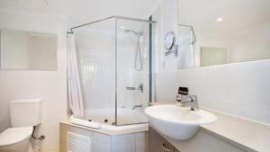 a bathroom with a shower and a sink and a toilet at Breathtaking - Ettalong Beach Resort in Ettalong Beach