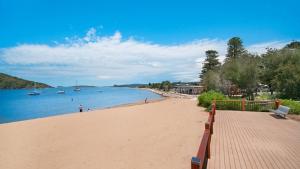 a sandy beach with boats in the water at Breathtaking - Ettalong Beach Resort in Ettalong Beach +5 photos